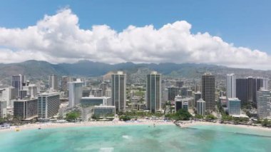 Modern okyanus manzaralı otel binaları. Güzel mavi okyanus manzaralı yüksek katlı lüks oteller. Yeşil dağ arka planında Waikiki plajı. Hawaii tatil beldelerinde ilham verici bir rüya gezisi.