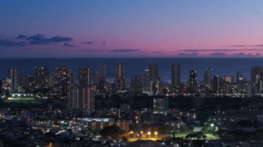 Waikiki şehir merkezi gün batımı manzarası. Honolulu 'nun başkenti Hawaii' de sinematik hava. Şehir üzerinde gece aydınlanan pembe gün batımı manzarası. Pasifik 'teki Oahu adasının modern şehir manzarası