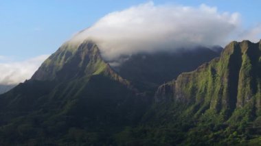Manzaralı Nuuanu Pali gözcüsü dağ zirvelerini bulutlarla kaplıyor. Kıyı kayalıkları zirvesi manzaralı sinematik bir hava. Fotokopi arkaplanı için destansı Hawaii manzarası. Oahu 4K 'da büyülü gün doğumu