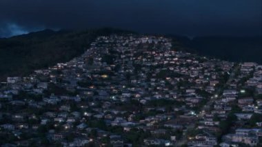 Geceleri Honolulu 'nun banliyö bölgesi Hawaii Eyaleti. Tropik Oahu adasındaki tepelerde emlak evleri. Waahila Ridge Eyalet Rekreasyon Bölgesi 'nin aşağısındaki yerleşim bölgesinin hava görüntüsü.