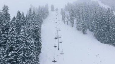 Stevens Pass kayak merkezinin kayak koltukları Washington 'da. Şiddetli kar fırtınasında sandalyede yürüyen kayakçılar. Stevens Pass kayak merkezi kış mevsiminde. Karlı dağ tepeleri kış günü beyaz karlarla kaplı.