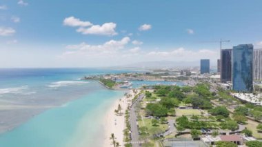 İnsanlar harika güneşli bir günde rahatlıyor. Hawaii adasında tatil gezisi. Güneşli yaz gününde Ala Moana plajı. Ala Moana Bölgesel Parkı üzerindeki hava sahası Honolulu şehir merkezi, ABD turizmi