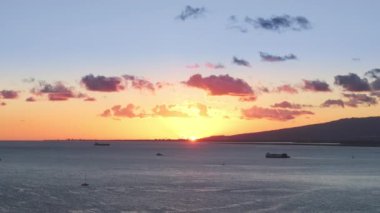 Hawaii adası altın saat parıltısında. Saf altın gökyüzü ve durgun okyanusla manzaralı yaz seyahati. Son güneş ışınları ufukta kayboluyor. Pasifik Okyanusu üzerinde sinematik altın gün batımı