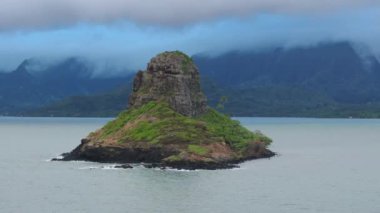 Mokolii volkanik adasının etrafında hareketli yeşil dağlarla dramatik bir hava. Oahu Adası Turizmi. Manzaralı doğa manzarası. Yağmurlu bir günde Çin adası havası. Kualoa 'da sinematik bulut.