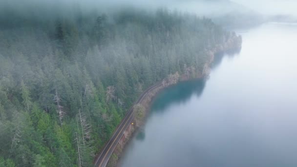 雾天沿着美丽的新月湖走风景路线 奥运国家公园内的空中电影常绿森林路 华盛顿雨林笼罩着神秘的雾 浓雾中的高大的绿色云杉 — 图库视频影像