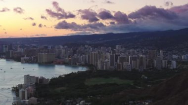 Honolulu şehir merkezinde mor bulutlu güzel pembe gün batımı. Hava Honolulu şehri, alacakaranlıkta. Hawaii, Oahu 'da günbatımında turistik bir yer. ABD turizmi 4K yaz tatili geçmişi