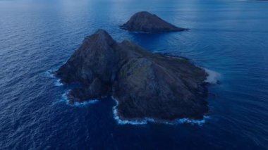 Oahu adasının rüzgarlı sahillerinde, Kayalık Na Mokulua adalarının üzerinde bir hava gecesi. İnsansız hava aracı kamerasının Hawaii turizm geçmişi. Açık hava macerası için manzara manzarası. Dokunulmamış Pasifik doğası