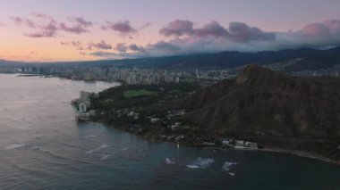 Honolulu ve Diamond Head 'in üzerinde güzel pembe bir günbatımı. Honolulu şehir merkezinde Diamond Head volkan kraterinin arkasında. Hawaii, Oahu 'da günbatımında turistik bir yer. ABD Turizmi 4K
