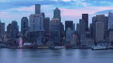 Karanlık çöktüğünde sahil şeridinin güzel şehir manzarası. Şehir mor gün batımında Washington semalarında parlıyor. Seattle şehir merkezinde, pembe günbatımında. Manzaralı Seattle silueti manzarası. Gece şehir merkezinde hava manzarası