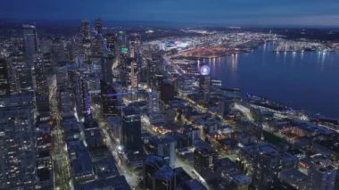 ABD Washington gün batımı gökyüzünün mor renkleri. Seattle şehir merkezinin ufuk çizgisine hava görüntüsü kuruluyor. Modern mimari deniz manzaralı gökdelen binaları ön planda, Seattle şehrinin arka planında