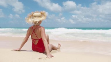 Kumsal tatilinde kırmızı mayo içinde güneşlenen mutlu kadın. Sıska kız mükemmel turkuaz okyanusta güneşleniyor. Tropikal tatil yapan seksi genç gezgin. Hawaii adası plaj tatili yavaş çekim