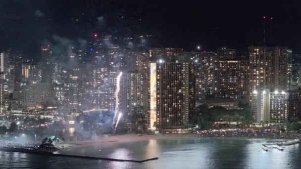 ハワイのオアフ島の観光名所 夏休みで人生を祝う人たち ホテルの夜空で風光明媚な花火が爆発する 金曜日の夜のワイキキラグジュアリーリゾートでのカラフルな花火 — ストック動画