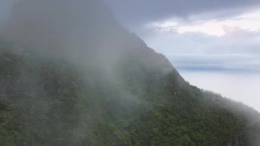 Yağmurlu bir günde sinematik tropikal doğa dağ manzarası. Yüksek dağların tepesinde bulut. Dramatik kopya arkaplanı. Yeşil ormanların zirvesinin manzarası. Bulutlu bir günde Kualoa çiftlik parkı