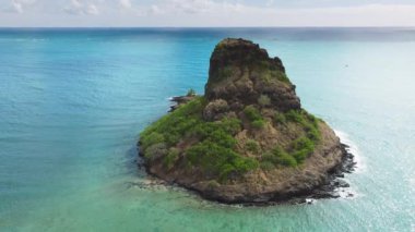 Kualoa dağlarındaki Mokolii volkanik adası hareketli arka planda. Yaz günü Çinlilerin şapka adası. Oahu seyahat rotası. Hawaii adasında eşsiz bir ekosistem ve çevre.