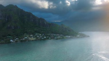 Okyanus kıyısı boyunca manzaralı bir rota, Oahu. Hawaii dağlarında parlayan sihirli günbatımı. Nehir kıyısındaki Kaawa kasabasında hava aracı. Kahekili Tepesi 'ndeki Sinen Aslan Yolu' nun altın güneş ışığı altında insansız hava aracı görüntüsü.