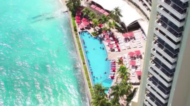 İnsanlar lüks Waikiki tatil köyündeki sonsuz havuzda yazın tadını çıkarıyorlar. Hawaii 'deki Oahu Adası' nda pahalı modern oteller. Waikiki plaj manzaralı mavi havuzda yüzen insanlar. ABD 'de yaz tatili