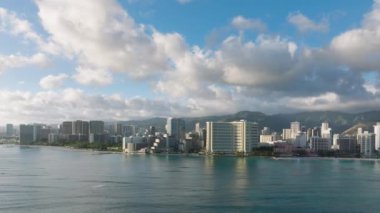 Hawaii adalarındaki havacılık şehri manzarası 4K USA. Güneşli bir günde Waikiki plaj tatil beldelerinde panoramik manzara. Honolulu 'nun ünlü Waikiki plajındaki modern otel binaları. Oahu adası turizm geçmişi