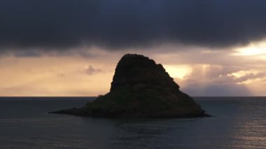 Yağmurlu bir sabahta Çin adasının kara silueti. Manzaralı doğa manzarası. Hawaii adası yaz gezisi geçmişi. Gün doğumunda okyanusun üstünde dramatik yağmur bulutları. Mokolii adası Oahu 'nun simgesi.