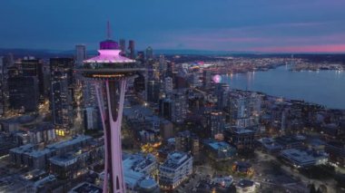 İş şehri USA 4K 'nın nefes kesici insansız hava aracı görüntüsü. Şehir merkezindeki manzaralı gözlem kulesinin etrafındaki havadan. Güzel gökyüzü olan, sinematik pembe günbatımında Seattle dönüm noktası.