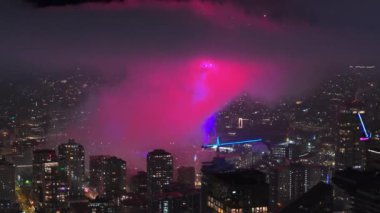 2024 yılının gece kutlamalarında havai fişek gösterisi. Seattle 'da çok güzel bir havai fişek gösterisi var. Geceleri bulutların içinde renkli havai fişekler patlıyor. Aydınlatılmış gözlem kulesinin etrafında havai fişek gösterisi