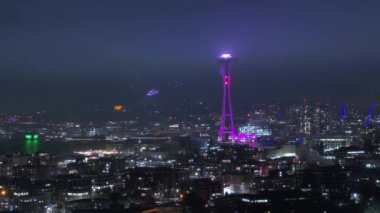 2024 yılının gece kutlaması. Geceleri güzel Seattle şehri. Şehir merkezindeki Seattle 'ın manzaralı gece antenleri. Gözlem kulesindeki ışık gösterisi gece aydınlandı. Yeni yıl arifesinde sinematik dönüm noktası