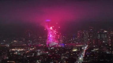 2024 yılının gece kutlamalarında havai fişek gösterisi. Gece şehir merkezinde güzel bir Seattle şehri. Geceleri renkli havai fişekler patlıyor. Gözlem kulesindeki havai fişek gösterisi gece aydınlandı, ABD