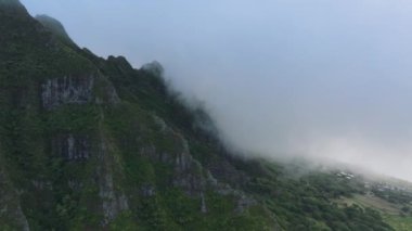 Havadaki karamsar bulutlar 4K 'nın yüksek tepelerini örtüyor. Dramatik karamsar günde sinematik görkemli tropikal dağ zirvesi. Yağmurlu çizgili uçurumlar, Jurassic Park manzaralı dağ manzarasında dramatik bir siluet oluşturdu