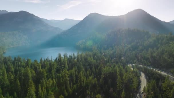 タホ湖の近くの濃い緑の森を曲げる太陽の光の道の空中観察は 上から撮影した静けさを自然にしています フッテージ — ストック動画