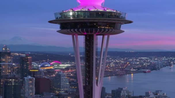 アメリカ合衆国ワシントン州シアトル 2023年12月28日 シアトル中心街の風光明媚な景色を背景に観測塔周辺の空中を閉じる 美しい空と映画のピンクの日没でのシアトルのランドマーク — ストック動画
