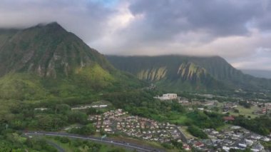 Hawaii adasının güzel doğası tropikal dağ manzarası. Cennet adasında yol konsepti yeşil yemyeşil ormanlarla kaplıdır. Yeşil bahçede manzaralı bir yol. H3 otoyolunun destansı rotası, Oahu Adası 4K