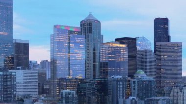 Alacakaranlık Seattle 'a iner, gökdelenlerin içini aydınlatır ve huzurlu bir akşam gökyüzüne karşı şehir mimarisi ile canlı bir tablo oluşturur. 4K görüntü. 