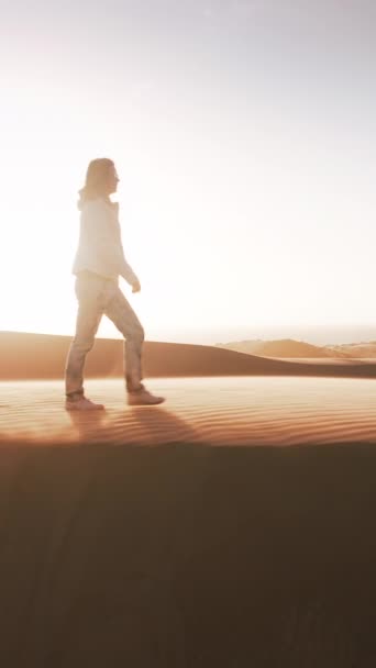 Pionowe Wideo Kobieta Ubrana Przechadzkę Przez Pustynny Krajobraz Pokryty Wydmami — Wideo stockowe