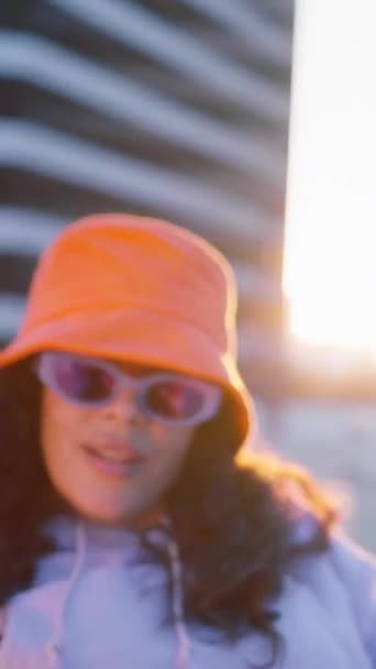비디오 민족성 여자는 생생한 오렌지 모자를 주위에 손으로 도시에 즐기는 비디오 클립