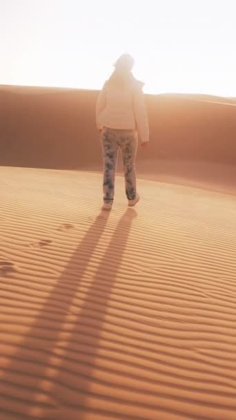 垂直录像 一个人独自站在广袤的干旱炎热的沙漠中 被无云的天空下的沙丘环绕 — 图库视频影像
