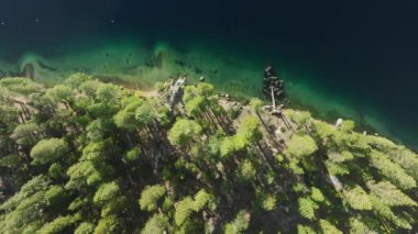 Bir dron Tahoe Gölü 'nü yukarıdan yakalar ve Kaliforniya, ABD' de yemyeşil ağaçlarla çevrili berrak mavi suları gösterir. 4K görüntü.