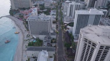 Waikiki şehrinin ufuk çizgisine bu gökyüzü perspektifinde uçsuz bucaksız okyanusun arka planına şahit olun. Uzun binalar, hareketli caddeler ve Pasifik Okyanusu 'nun sakin suları görünmeye başlar..