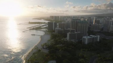 Video, Waikiki 'nin canlı şehrine ve onu çevreleyen okyanusun engin genişliğine dair havadan bir perspektif gösteriyor. Kamera, el değmemiş sularla kusursuz bir şekilde harmanlanmış şehir manzarasını yakalıyor.