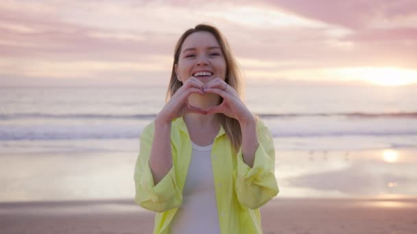 Playful Young Lady Bright Yellow Shirt Forms Heart Her Fingers Video Clip