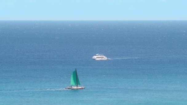 一艘带着绿色帆和游艇的帆船在夏威夷瓦胡岛附近广阔的蓝色太平洋水域中穿行 4K镜头 — 图库视频影像