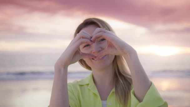 Delighted Young Woman Wearing Light Yellow Shirt Makes Heart Shape — Stock videók