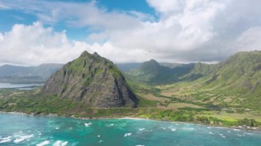 Okyanusun ortasında bulunan tropikal bir ada olan Kualoa 'nın havadan bakış açısını deneyin. Bereketli yeşilliği, berrak suları ve yukarıdan çarpıcı kıyı şeridini keşfedin..