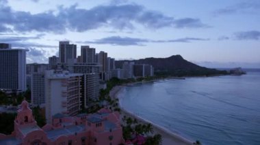 Sabah Waikiki 'nin üzerine çökerken, ilk ışık şehri sıcak bir ışıltıyla yıkayarak Oahus sahilinin canlılığını gözler önüne seriyor. Zaman aşımı. 4K görüntü. 