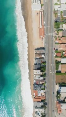 Kaliforniya, Malibu 'daki Sandy Sahili' ne çarpan Turkuaz Dalgalar 'ın dramatik hava çekimi. 4K Görüntü. 