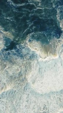 Dikey Ekran: Nazare, Portekiz 'de çarpan okyanus dalgalarının çarpıcı dikey görüntüsünün keyfini çıkarın, manzaralı arka planlar için ideal. Denizin güzelliğini ve dinamik dalgalarını yakalamak için mükemmel.