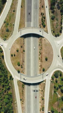 Dikey Ekran: Üst geçitleri ve köprüleri dikey ekran üzerinde olan, kentsel altyapı ve ulaşım ağını gösteren dairesel otoyol kesişiminin yüksek çözünürlüklü hava görüntüsü