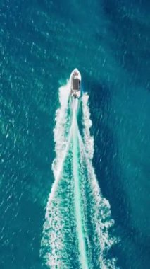Dikey ekran: Hava görüntüleri bir sürat teknesini yakalar ve dikey ekranda güneşli bir gökyüzünün altında derin mavi sularda bir uyanış yaratır. Sahne hem dinamik hem de dinamiktir. Huzurlu ama heyecan verici bir manzara sunar.
