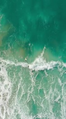 Dikey ekran: Yalnız bir sörfçüye bu büyüleyici hava görüntülerinde ustalıkla okyanus sularında sörf yaparken tanık olun.
