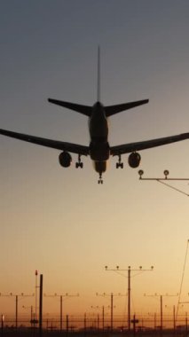 Dikey ekran: Alacakaranlık Havaalanı 'na inen bir uçağın dikey videosunu izleyin, günbatımı arka planına karşı havacılığın güzelliğini göstermektedir. Uçağın alçalmasını, yaklaşmasını ve inişini görün.