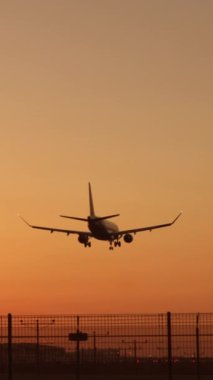 Dikey ekran: Dikey video, havacılık ve doğayı güzel bir şekilde birleştirerek, nefes kesici bir günbatımı batımına inen bir uçağı tasvir ediyor. Fevkalade bir arka plana karşı uçmanın özünü yakalar.