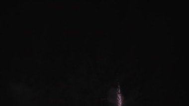 Gece gökyüzünde patlayan kırmızı havai fişeklerin büyüleyici bir görüntüsü 120 fps hızla ağır çekimde çekildi. Havai fişeklerin güzelliğine ve ihtişamına tanık olun..